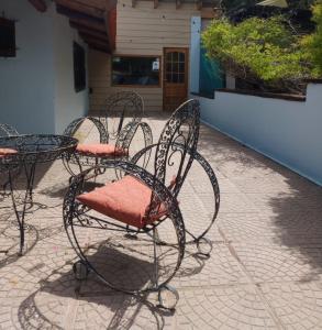 圣卡洛斯-德巴里洛切Cuatro Cerros Hostel的庭院里摆放着红色座椅的一组椅子