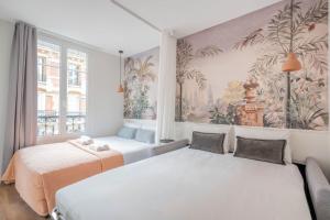 巴黎Résidence Le Belleville的一间卧室设有两张床,墙上挂着一幅画