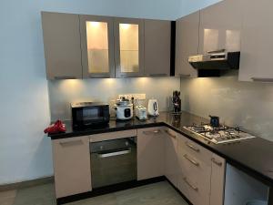 科伦坡No 10 @ Carlwil place的厨房配有白色橱柜和炉灶烤箱。