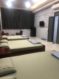 Xã Bình HòaNhà Nghỉ A&Em的客房设有三张床和一台平面电视。