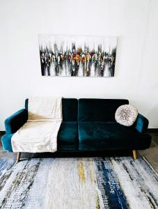 MatouryLa Villa Louisia的客厅里一张黑色的沙发,上面有绘画作品