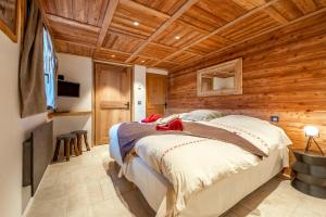 圣莫里斯堡Chalet savoyard d'exception avec piscine chauffée的木制客房内的一间卧室,配有一张床