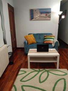 贝梅奥Apartamento Etxe Morea, Casco Histórico的客厅配有蓝色的沙发和桌子