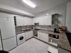 迈阿密普拉特亚Apartamento California 3的厨房配有白色橱柜、洗衣机和烘干机