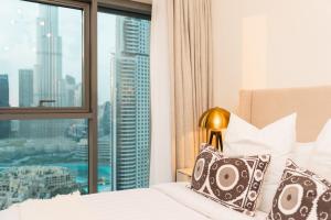 迪拜BURJ ROYAL-Luxurious 2 Bedrooms -DOWNTOWN-Burj & Fountain View的一间卧室设有一张床和一个大窗户