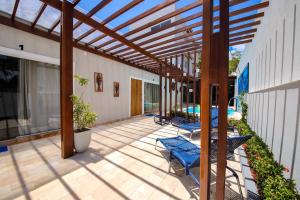 马拉戈日O Azul de Maragogi - Pousada Premium的庭院设有蓝色椅子和木制凉亭。