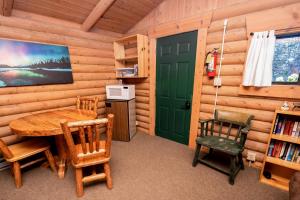 比格福克Experience Montana Cabins - Birdsong #2的一间设有绿门和桌椅的用餐室