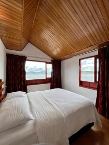 阿基塔尼亚Hotel Refugio Santa Ines的一间卧室设有一张大床和两个窗户。