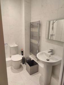 Laindon2 bedroom en-suite apartment in Basildon, Essex (Enjoy the simple things in life)的白色的浴室设有卫生间和水槽。