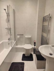 Laindon2 bedroom en-suite apartment in Basildon, Essex (Enjoy the simple things in life)的白色的浴室设有卫生间和水槽。