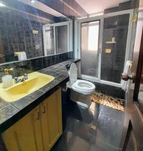 基多The Temple, Quito的浴室配有白色卫生间和盥洗盆。