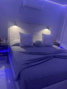拉斯维加斯Fantastic Suite的一间卧室配有一张蓝色灯的大床