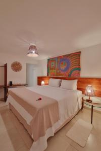 佩德拉斯港Pousada Rota Ecológica的卧室配有一张大床,墙上挂有绘画作品