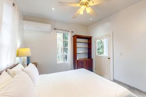 库尔克岛Casa Tranquila的卧室配有白色的床和吊扇