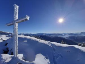 斯陶达奇格达赫Ferienwohnung Bergliebe的雪覆盖的山顶上的十字架