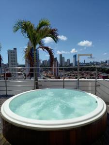 若昂佩索阿Manaíra Apart Hotel - 1606的屋顶上的热水浴池,种植了棕榈树