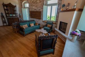 桑加拉达Nostos Country House的客厅配有沙发、椅子和壁炉