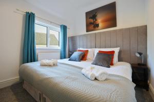 麦克尔斯菲尔德Cottage Cross by YourStays的一间卧室配有一张大床和毛巾