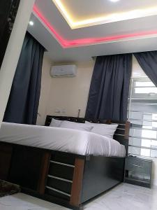 拉各斯JKA 1-bed Luxury apartments的一张位于带天花板的客房内的大床
