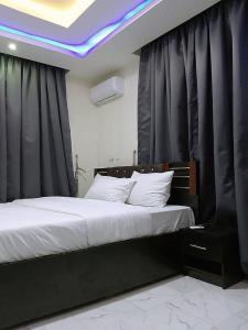 拉各斯JKA 1-bed Luxury apartments的一间卧室配有一张大床和黑色窗帘
