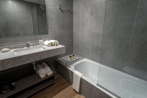 布宜诺斯艾利斯Barrancas Quality Apartments的带浴缸、水槽和镜子的浴室