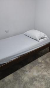 TrujilloJARDIN CAFETERO的一张带白色床单和枕头的床