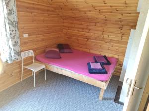 IkšķileToma pirts BRĪVDIENU的小房间设有粉红色的床和椅子