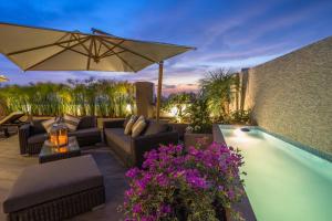 利马何塞·安东尼奥豪华酒店的一个带沙发和遮阳伞的庭院,毗邻一个游泳池