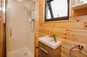 约克Little Meadow Pods with Hot Tub的一间带水槽、淋浴和卫生间的浴室