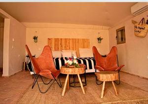 Aït DaoudThe Original Camp的客厅配有桌椅和1张床