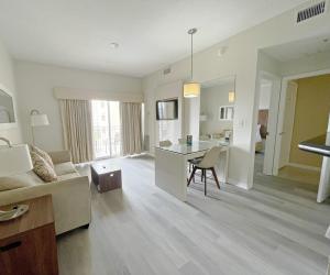 奥兰多环球影城蓬特套房酒店的客厅配有沙发和桌子。