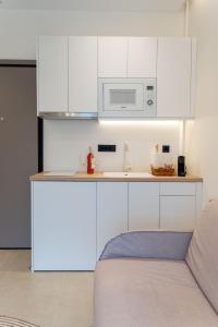 约阿尼纳CLIC suite and family的厨房配有白色橱柜和微波炉