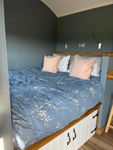 滕比Old Quay Escape的一张带蓝色棉被和粉红色枕头的床
