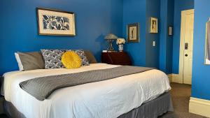 克利夫兰Stone Gables Inn的一间拥有蓝色墙壁和一张大床的卧室
