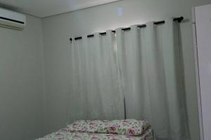 彼得罗利纳Casa Mobiliada Nova em Petrolina的卧室配有白色窗帘和床。