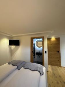圣迈克尔隆高DAS MANFRED的卧室配有白色的床和镜子