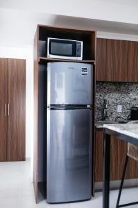 巴亚尔塔港Monyxbnb Hotel的厨房配有不锈钢冰箱和微波炉。