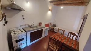 蒂尔卡拉Cabañas Tierra Andina的厨房配有炉灶、水槽和一些椅子