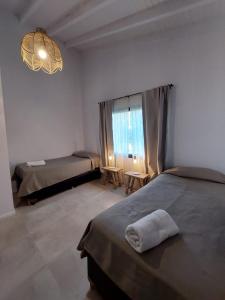 拉安戈斯图拉镇Al pie del Cerro的一间卧室设有两张床和大窗户