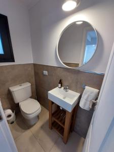 拉安戈斯图拉镇Al pie del Cerro的一间带卫生间、水槽和镜子的浴室