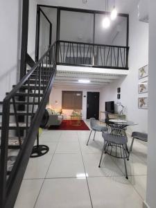 巴拿马城Loft Centrico Tranquilo Elegante APART #6的客厅设有楼梯和桌椅