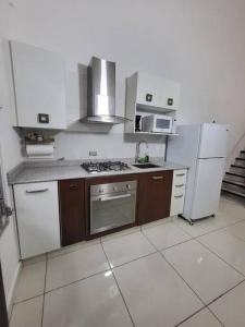巴拿马城Loft Centrico Tranquilo Elegante APART #6的厨房配有炉灶和冰箱。