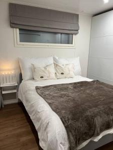 罗瓦涅米Arctic Circle Guesthouse的卧室配有一张带白色床单和枕头的大床。