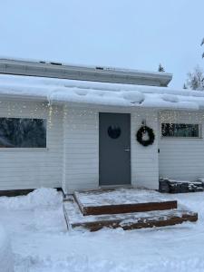 罗瓦涅米Arctic Circle Guesthouse的雪中盖有门的房子