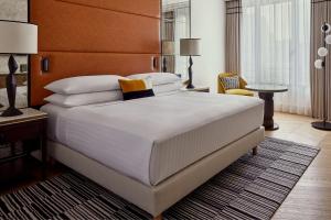 巴黎巴黎香榭丽舍大道万豪酒店的卧室配有一张白色大床和棕色床头板