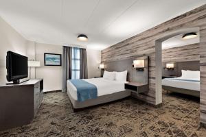 列治文山Best Western Parkway Hotel Toronto North的酒店客房设有两张床和一台平面电视。
