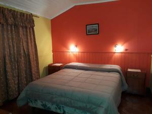 伊瓜苏港罗斯赫勒朝斯旅馆的一间设有床铺的卧室,位于一个红色墙壁的房间