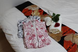 东京赤羽Japanese-Style private Villa & Bike的床上有衣服和毛巾