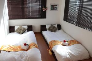 东京赤羽Japanese-Style private Villa & Bike的一间设有两张床的房间,里面装满了动物