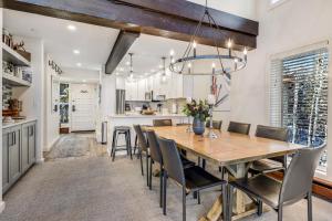 斯诺马斯村Interlude Condominiums 3-Bedroom Unit 301的厨房以及带木桌和椅子的用餐室。